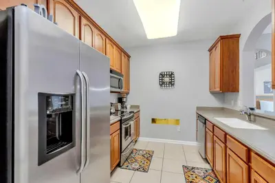 a kitchen with a stainless steel refrigerator and wooden cabinets at Conservation View Updated WOW in Orlando