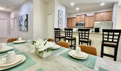 a kitchen and dining room with a table and chairs at Cheerful 5 Bdr Sunny Pool in Kissimmee