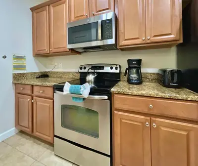 a kitchen with a stove and a microwave at Cheerful 5 Bdr Sunny Pool in Kissimmee