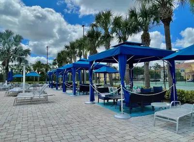 a group of blue umbrellas and hammocks at Cheerful 5 Bdr Sunny Pool in Kissimmee