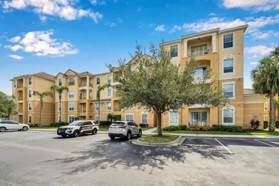 a large apartment building with cars parked in a parking lot at Vista Cay Remodeled WOW in Orlando