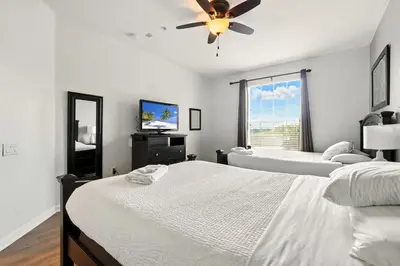 a bedroom with two beds and a ceiling fan at Direct Lake Front View Luxury in Orlando