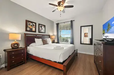 a bedroom with a bed and a ceiling fan at Direct Lake Front View Luxury in Orlando