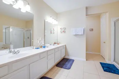 a bathroom with two sinks and a large mirror at Lake Front huge by clubhouse in Orlando