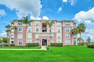a pink building with palm trees in front of it at Huge Updated Stunner Corner in Orlando
