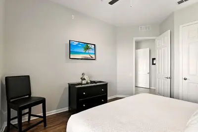 a bedroom with a bed and a chair at WOW Upscale Penthouse in Orlando