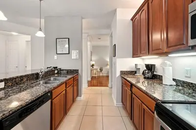a large kitchen with wooden cabinets and granite counter tops at Huge Luxury Ground Floor 103 in Orlando