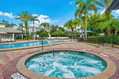 a hot tub with palm trees in the background at Totally Remodeled Beauty WOW in Orlando