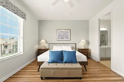 a bedroom with a bed and a chair and a window at Huge Stunning Corner Home 304 in Orlando