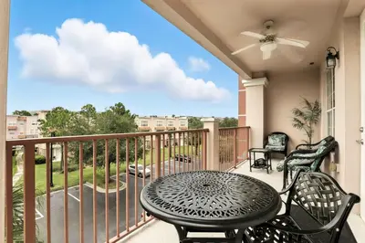 a patio with a table and chairs on a balcony at Huge Stunning Corner Home 304 in Orlando