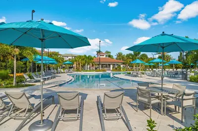a pool at a resort with chairs and umbrellas at Huge Stunning Corner Home 304 in Orlando