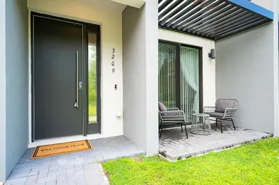 a front door of a house with two chairs and a table at Luxury Town House Near Disney in Kissimmee