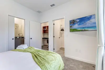 a bedroom with a bed and a painting on the wall at Luxury Town House Near Disney in Kissimmee