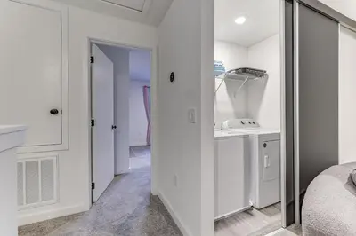 a bedroom with white walls and a bathroom with a sink at Luxury Town House Near Disney in Kissimmee