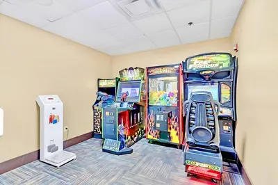 a room with three arcade games and a wii at Stylish King Apt w Arcade Game & BBQ Near Disney in Orlando