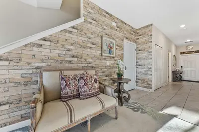a living room with a couch and a brick wall at Gorgeous 5Bd w Pool & Lazy River at Storey Lake 4989 in Kissimmee