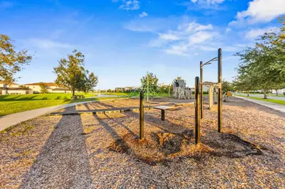 an empty park with a bench and a street at Gorgeous 5Bd w Pool & Lazy River at Storey Lake 4989 in Kissimmee