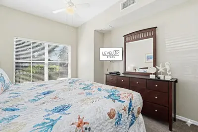 a bedroom with a bed and a dresser and a mirror at Disney 8mi Heated Resort Pool Hot Tub Fitness in Kissimmee