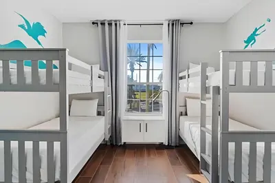 a bunk room with two bunk beds and a window at Vista Cay: 4Q c/ Varanda e Mesa de Pebolim in Orlando