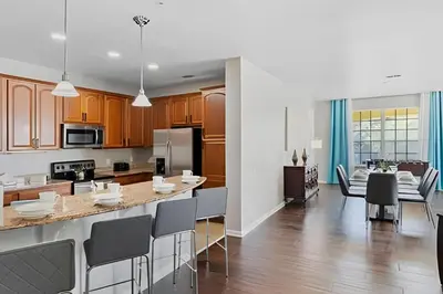 a kitchen and dining room with a table and chairs at Vista Cay: 4Q c/ Varanda e Mesa de Pebolim in Orlando