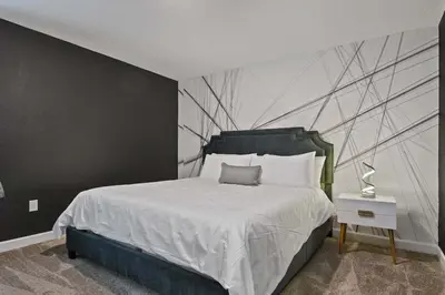 a bedroom with a bed with a black and white wall at 9 MI to Disney w Pool Cinema & FREE Waterpark in Kissimmee