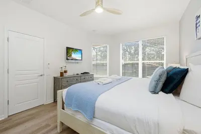 a white bedroom with a bed and a ceiling fan at Disney Family Escape - Stunning 5-Bed Villa with Private Pool in Orlando