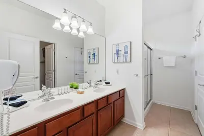 a bathroom with a sink and a large mirror at Disney Family Escape - Stunning 5-Bed Villa with Private Pool in Orlando