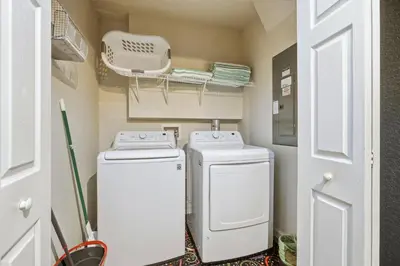 a small laundry room with a washer and dryer at Disney Family Escape - Stunning 5-Bed Villa with Private Pool in Orlando