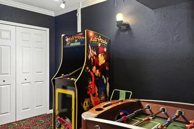 a room with a video game machine in a room at Disney Family Escape - Stunning 5-Bed Villa with Private Pool in Orlando