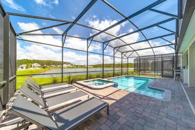 a glass house with a pool and two lounge chairs at Themed 9BR Retreat Pool & Soccer Fun in Kissimmee