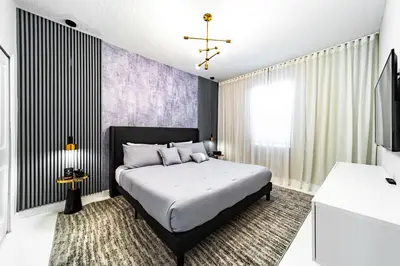 a bedroom with a large bed and a tv at Themed 9BR Retreat Pool & Soccer Fun in Kissimmee