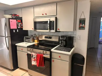 a kitchen with a stove and a microwave at Disney Magic Condo 1st Flr 3BR Disney-Themed Pool in Kissimmee