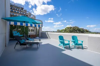 a patio with chairs and a table and an umbrella at Studio with Private Terrace and Volcano Bay View Near Epic Universe in Orlando