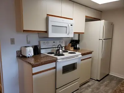 a kitchen with a white stove top oven next to a refrigerator at 3beds 2baths Condo in Kissimmee, FL in Kissimmee