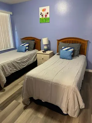 a bedroom with two beds with blue walls at 3beds 2baths Condo in Kissimmee, FL in Kissimmee