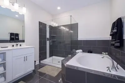 a large bathroom with a tub and a shower at Spacious Villa w Pool Slides and Lush Nature Views in Kissimmee