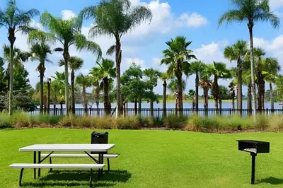 a picnic table in a park with palm trees at Townhouse Moderna 4Q — Perto da Universal in Orlando