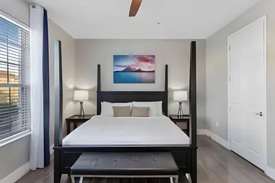 a bedroom with a large bed and two windows at Townhouse Moderna 4Q — Perto da Universal in Orlando