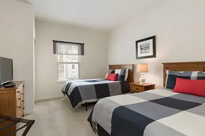 a bedroom with two beds and a television in it at Townhouse 3Q Perto da Disney c/ Mickey Room in Kissimmee