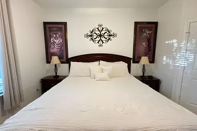 a bedroom with a large white bed with two lamps at Condo 3Q Windsor Hills — Perto da Disney in Orlando