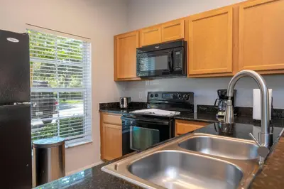 a kitchen with a sink and a microwave at Cozy 2 bedrooms with Hot tube in Kissimmee