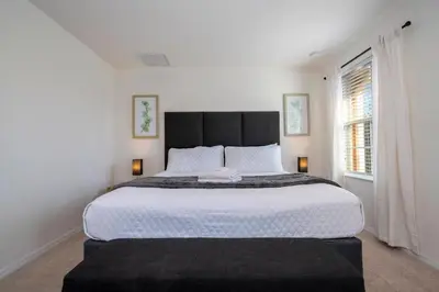 a bedroom with a large bed and a window at Cozy 2 bedrooms with Hot tube in Kissimmee