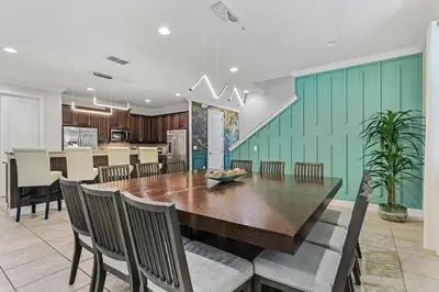 a dining room and kitchen with a wooden table and chairs at Magical Memories Villa 10bd Near Disney in Orlando