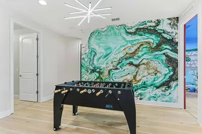a ping pong table in front of a painting at Magical Memories Villa 10bd Near Disney in Orlando