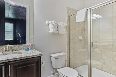 a bathroom with a toilet and a glass shower at Magical Memories Villa 10bd Near Disney in Orlando