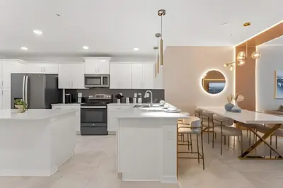 a kitchen with white cabinets and a table with chairs at Apto 2Q Storey Lake — Vista Lago e Clube in Kissimmee