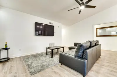 a living room with a couch and a flat screen tv at 3 Mi to SeaWorld! Suburban Home with Screened Porch in Orlando