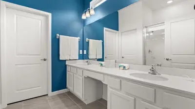 a bathroom with a white sink and a blue wall at Upstay Veranda Palms Villa Pool Hot Tub & Games in Kissimmee