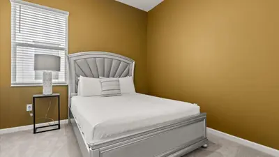 a bedroom with a white bed and a window at Upstay Veranda Palms Villa Pool Hot Tub & Games in Kissimmee