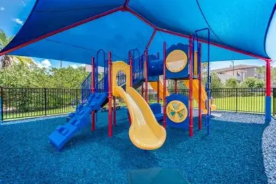 a playground with a slide in a blue canopy at Apartamento 3Q no Vista Cay Resort in Orlando